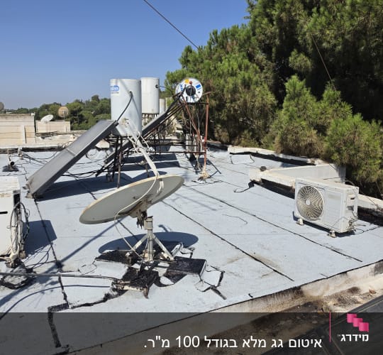 גג שטוח המכוסה ביריעות ביטומניות עם דודי שמש ומזגנים
